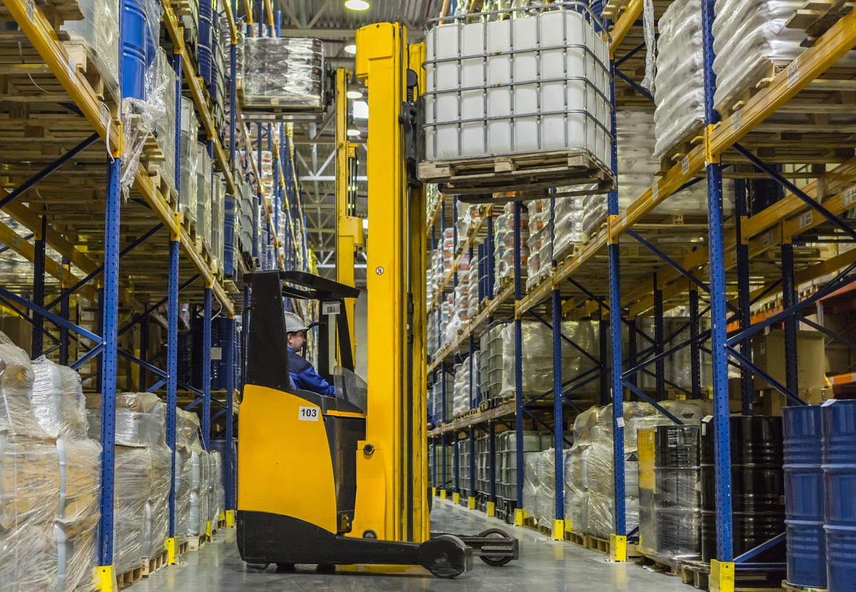 warehouse-worker-on-stacker-loading-cargo-on-shelf-2021-10-07-17-15-31-utc